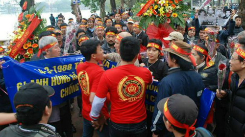 Nhóm người mặc áo đỏ in chữ "DLV" giăng cờ đỏ búa liềm trước tượng đài, ngăn cản người dân đặt hoa, thắp hương tưởng niệm các liệt sĩ Gạc Ma.